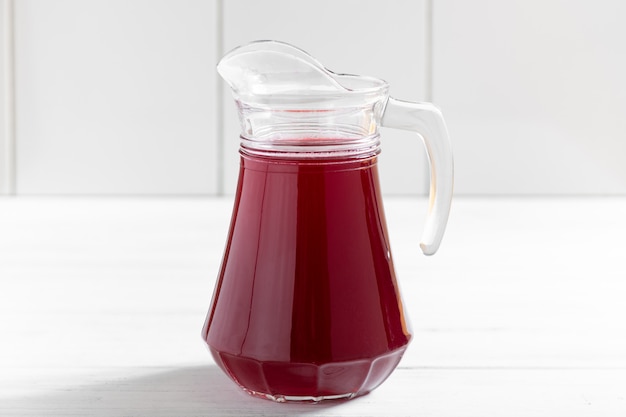 Glass jar of currants berry drink on wooden table