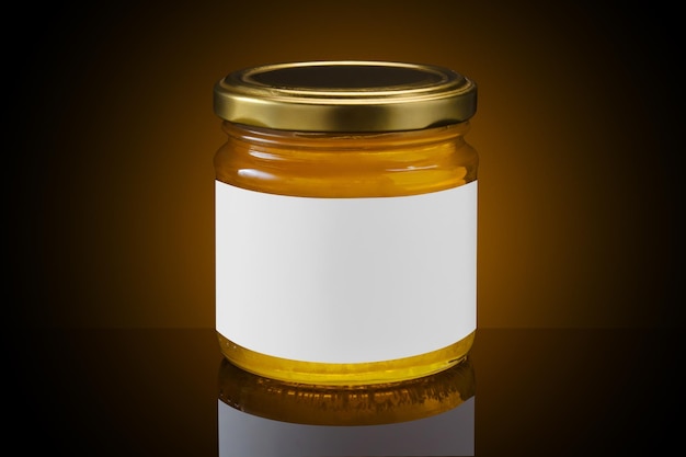 Glass jar full of honey with white label on dark background