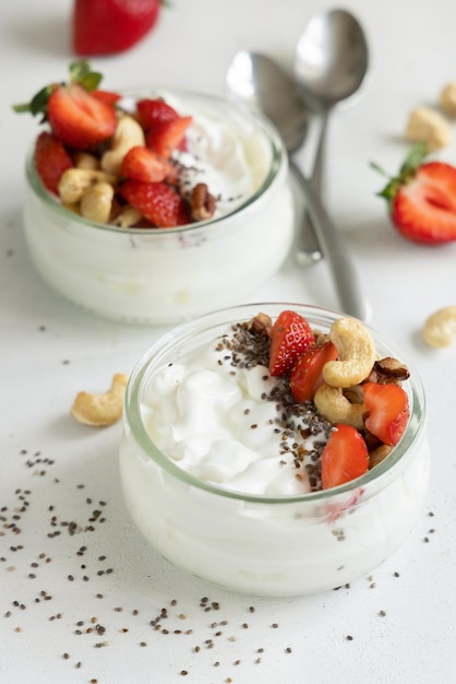 Glass jar of Greek yogurt nuts and strawberries on a tray close up copy space