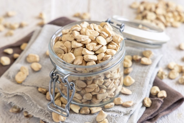 Glass jar of raw dry Grass pea on kitchen towel close up Italian legumes Cicerchia