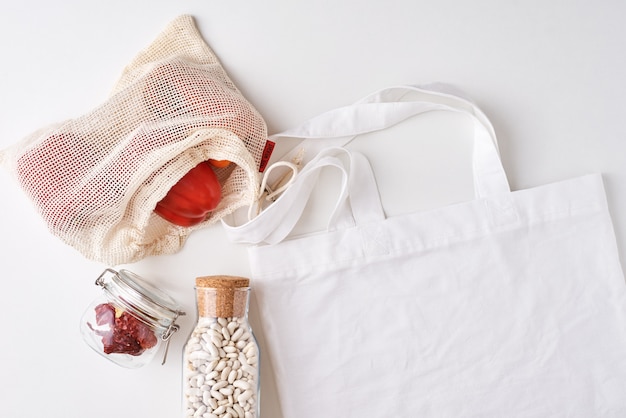 Glass jar and shopping bag with fresh vegetables