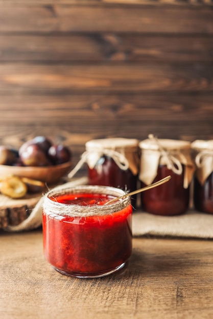 Glass jar with delicious homemade plum jam on table