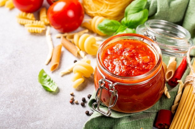 Glass jar with homemade classic spicy tomato pasta or pizza sauce.