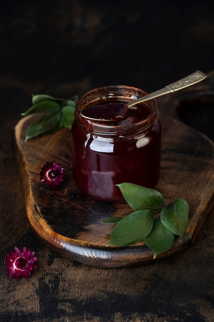 Glass jar with homemade jam on a dark surface