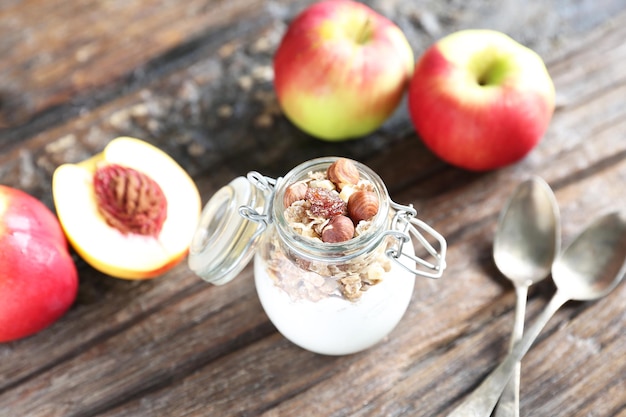 Glass jar with yogurt granolla and almond nuts in it