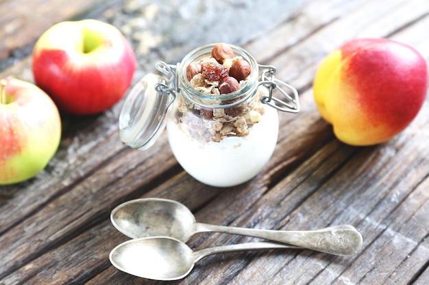 Glass jar with yogurt granolla and almond nuts in it