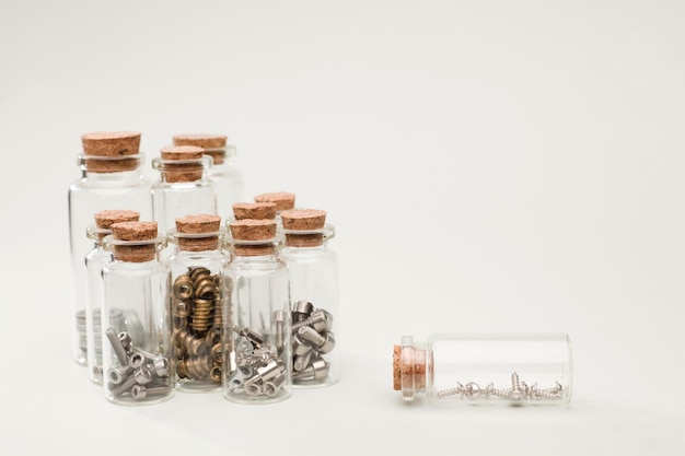 glass jars with cork, organization of nails screws, nuts with soft green background