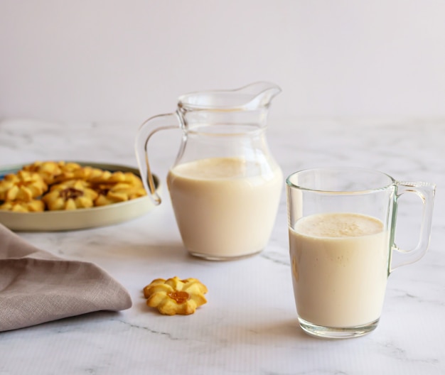 A glass jug and the glasses with fermented baked milk. 