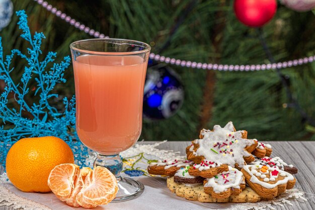 Glass of juice mandarins and a fir tree with Christmas ornaments