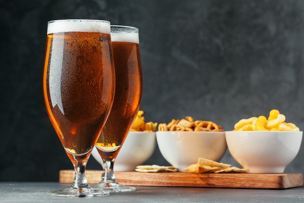 Glass of lager beer with snack bowls