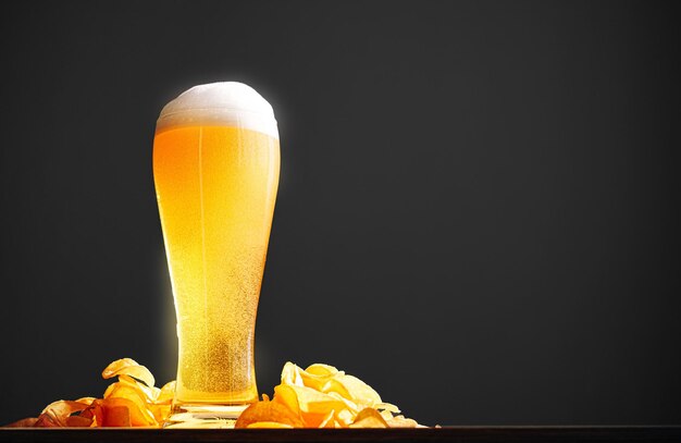 A glass of light beer ale on the bar with chips nearby side view place for text banner