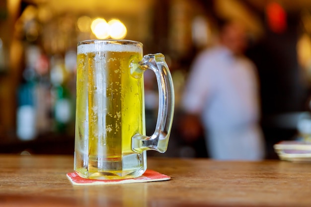 Glass of light beer in a traditional style pub at the bar counter soft focus