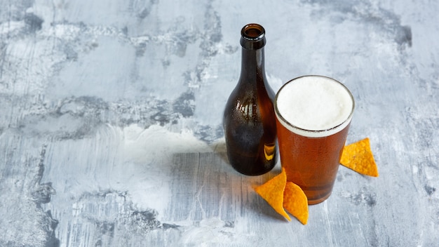 Glass of light beer on white stone surface