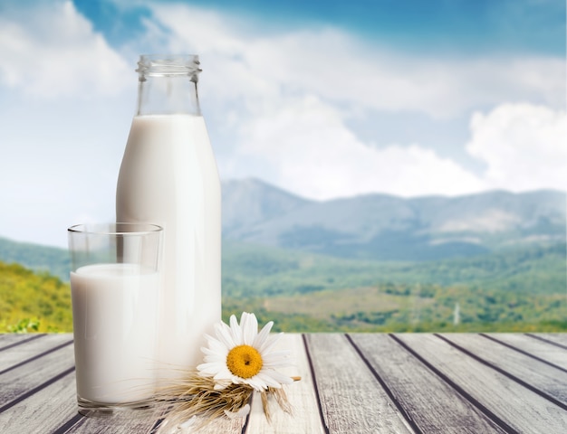 Photo glass of milk and bottle on  background