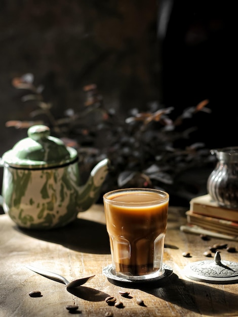 A glass of milk coffee in transparant glass on the table