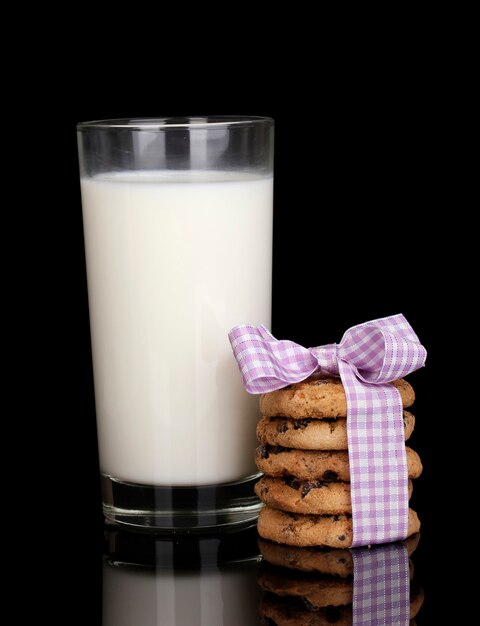 Glass of milk and cookies isolated on black