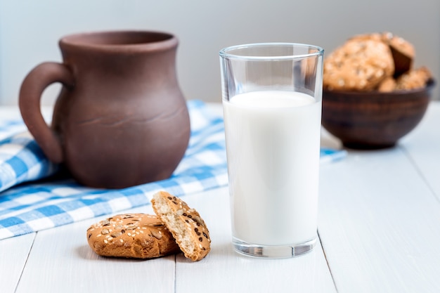 Glass of milk and cookies on wooden table