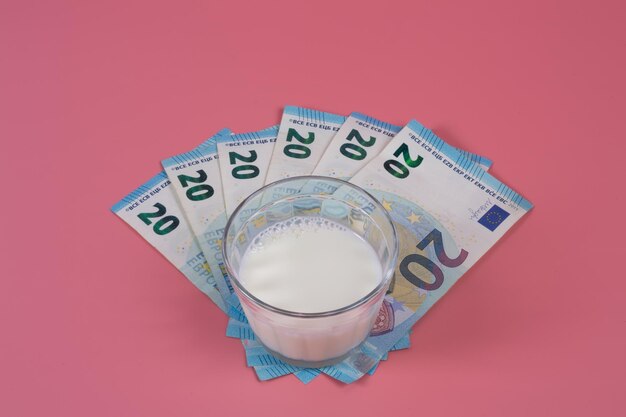 A glass of milk over a handful of euro banknotes