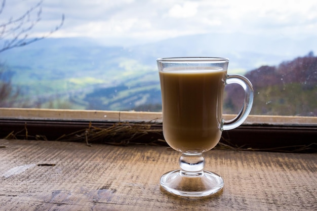 Glass of milk hot drink in the mountains