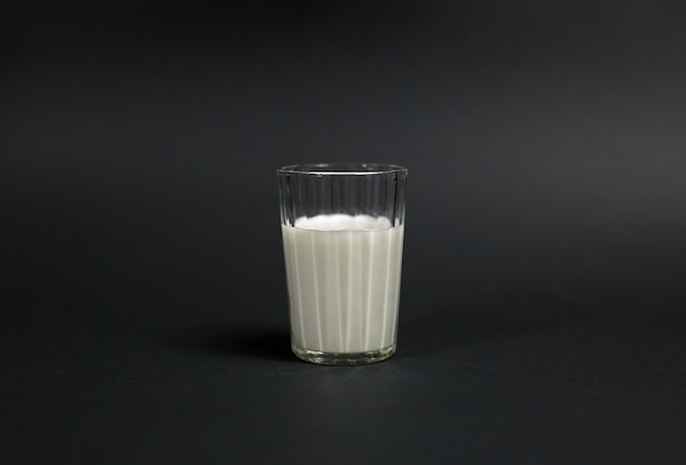 Photo a glass of milk is placed on a black background