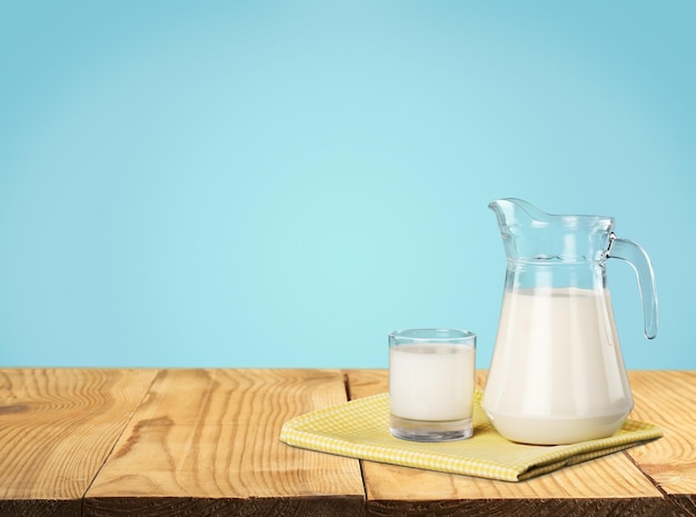 Glass of milk and jug on  background