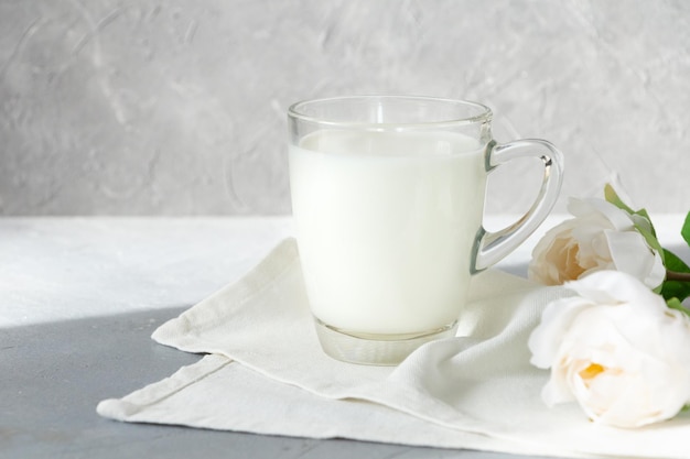 A glass of milk on a napkin decorated with white flowers high quality photo