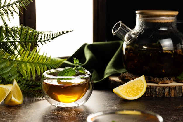 A glass mug with tea in the light is on the table Custard tea with lemon