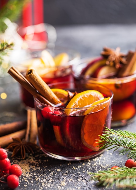 Glass mugs of mulled wine with spices and citrus fruits. Traditional hot drink or beverage, festive cocktail at X-mas or New Year