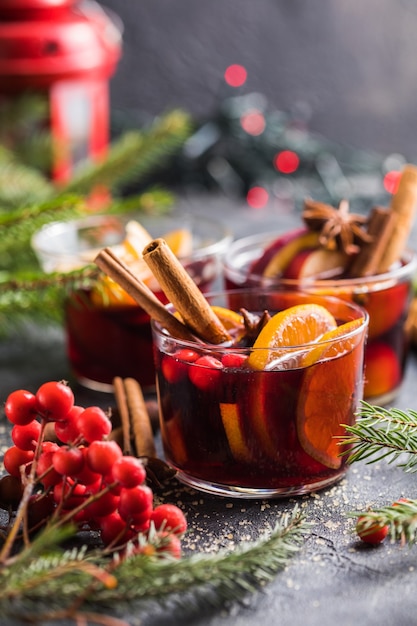 Glass mugs of mulled wine with spices and citrus fruits. Traditional hot drink or beverage, festive cocktail at X-mas or New Year