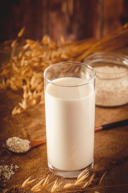 Glass of oat milk on a wooden background