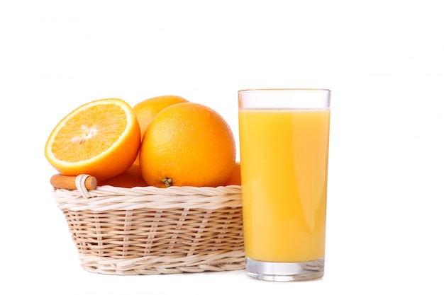 Glass of orange juice and orange in basket