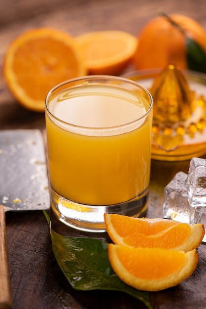 Glass of orange juice on wooden table close up