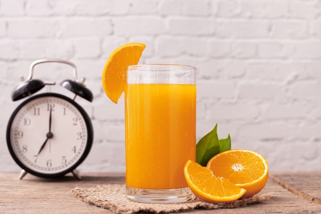 Glass of orange juice on wooden table.