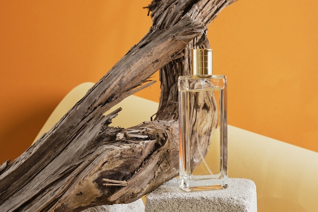 Glass perfume bottle in driftwood, natural shade background