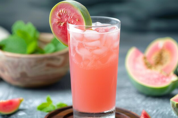 a glass of pink juice with a slice of lime on it