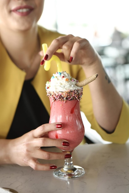 Glass of raspberry milkshake with whipped cream and fresh raspberries