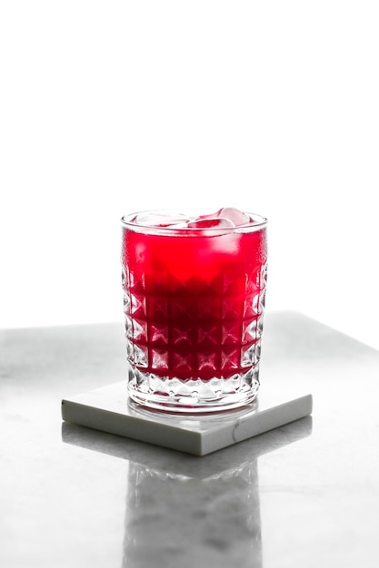 Glass of red cocktail with ice luxury bar party