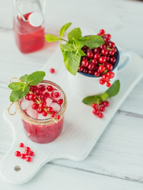 Glass of red currant cocktail or mocktail, refreshing summer drink with crushed ice and sparkling water