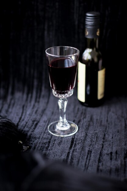 Glass of red wine on a black velvet background closeup