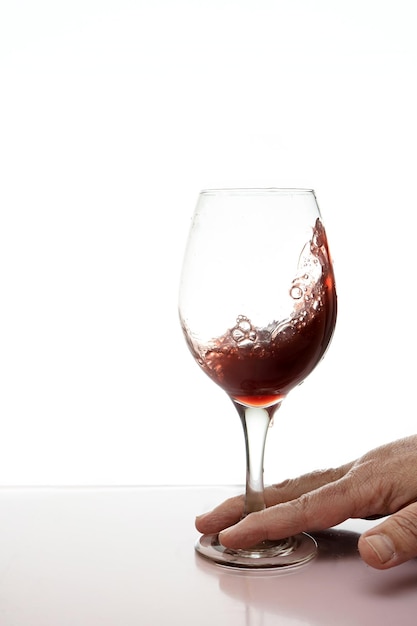 Glass of red wine splashing isolated