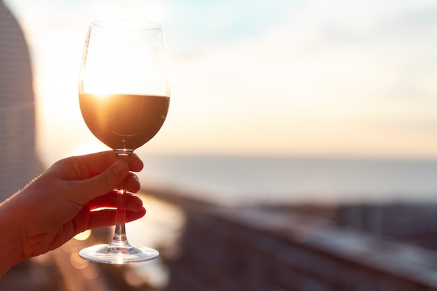 A glass of red wine at sunset.