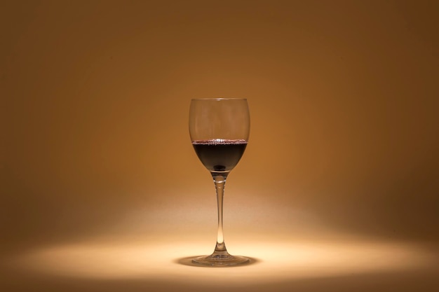 Glass of red wine on a warm background created with intimate lighting