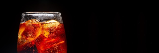 glass of soft drink on black background,Soft drink glass with ice splash on dark background.