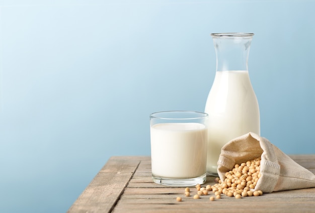 Glass of soy milk with bottle and soybeans