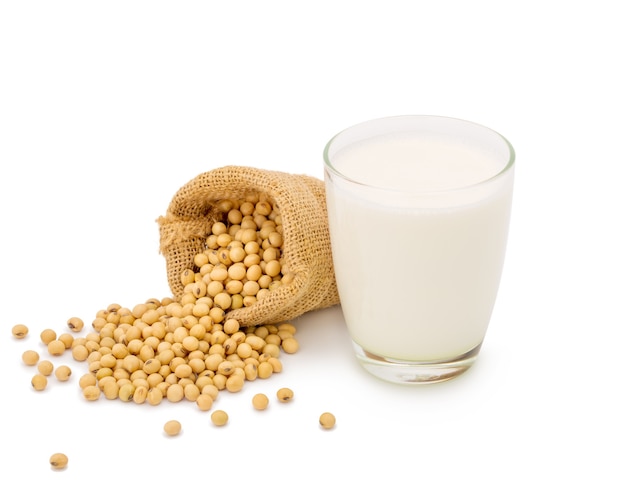 Glass of Soy milk with soybeans in bag isolated on white space.