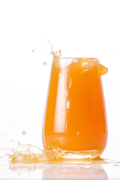 The glass of splashing fruit juice isolated isolated