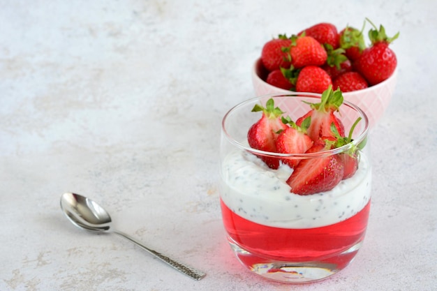 Photo a glass of strawberry dessert with strawberries yogurt chia seeds and a spoon