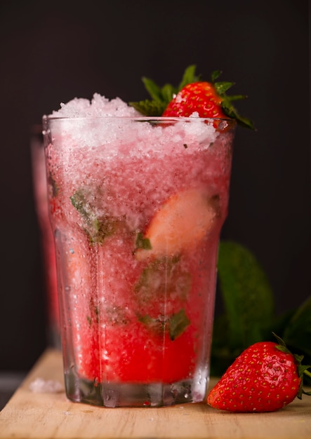 Glass of strawberry drink on a dark background