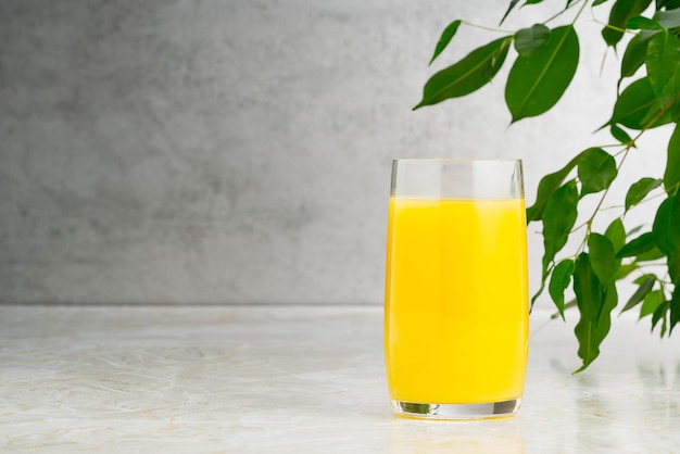 Glass of tasty orange juice on table glass of orange juice with copy space on grey background