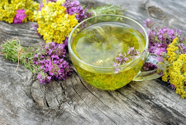 a glass of tea with a bunch of lavender flowers on a wooden table